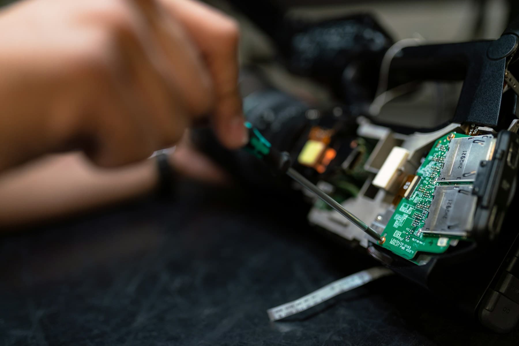 Feinmechanische Reparaturarbeit an einer geöffneten Platine
